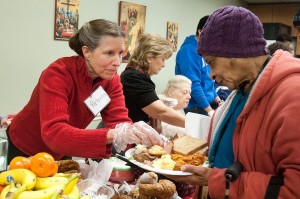 Volunteers at St. Matthew’s Cathedral serve a hot breakfast to guests at the Christmas breakfast on Dec 15.